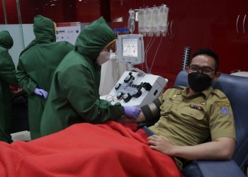 Kabag Humas Pemkot Surabaya Febriadhitya Prajatara saat donor plasma konvalesen di PMI Surabaya.
