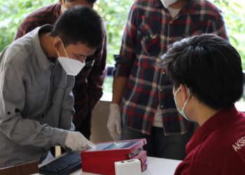 Pengguna memasukkan data diri mereka ke dalam alat i-nose c-19.