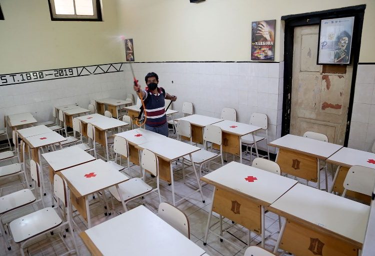 Petugas sekolah melakukan penyemprotan disinfektan di salah satu kelas di SMPN 3 Surabaya yang akan digunakan sebagai ruang pembelajaran tatap muka terbatas.