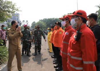 Wali Kota Surabaya Eri Cahyadi, diikuti jajaran Forum Koordinasi Pimpinan Daerah (Forkopimda) Surabaya menyapa pasukan penanggulangan bencana dalam apel di halaman Balai Kota.