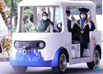 Dr Rudi Dikairono ST MT (bertoga), wisudawan program doktor dari program studi Teknik Elektro FTEIC yang datang bersama istri dan putranya mengendarai mobil listrik tak berawak i-Car.