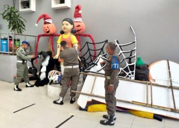 Personel gabungan dari Satpol PP, Linmas dan Satgas Covid-19 Kota Surabaya membongkar replika boneka Squid Game yang berdiri di Jalan Tunjungan.