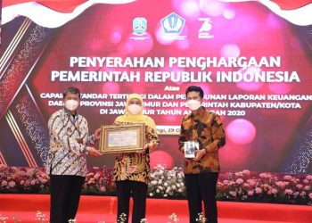 Gubernur Khofifah Indar Parawansa diosampingi wagub Emil Elestianto Dardak menerima penghargaan opini Wajar Tanpa Pengecualian (WTP) dari pemerintah pusat yang diserahkan oleh Kepala Kanwil Ditjen Perbendaharaan. Jatim Kemenkeu RI Taukhid di Ballroom Hotel Kokoon Banyuwangi.