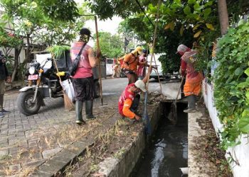 Personel dari DKRTH melakukan pembersihan saluran air di salah satu titik di Surabaya.