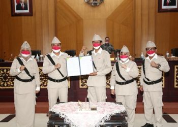 Ketua DPRD Surabaya Adi Sutarwijono memegang berita acara pengesahan APBD Surabaya tahun 2022 bersama Wali Kota Eri Cahyadi disaksikan pimpinan DPRD Surabaya yang lain.