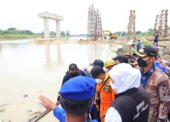 Gubernur Jatim Khofifah Indar Parawansa meninjau lokasi kecelakaan perahu penyeberangan di Bengawan Solo dengan latar belakang jembatan Kabupaten Tuban-Bojonegoro yang masih dibangun.