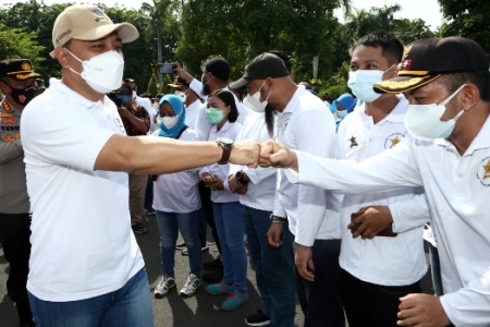 Wali Kota Surabaya Eri Cahyadi tos dengan warga pada peluncuran program Kalimasada (Kawasan Lingkungan Masyarakat Sadar Adminduk) dalam apel bersama yang berlangsung di halaman Balai Kota Surabaya.