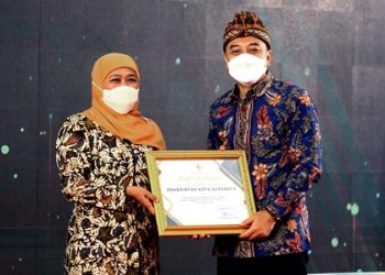 Gubernur Provinsi Jawa Timur, Khofifah Indar Parawansa menyerahkan penghargaan kepada Wali Kota Surabaya Eri Cahyadi dalam acara Peringatan Hari Kesehatan Nasional yang berlangsung di Kota Mojokerto.