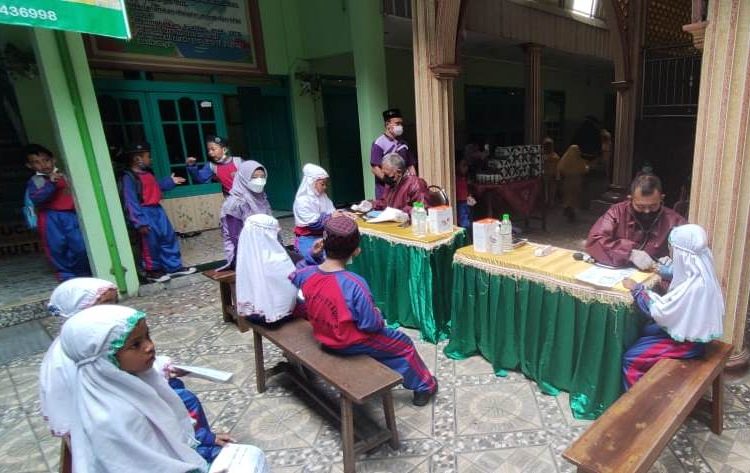 Pelaksanaan vaksinasi Covid-19 oleh Pusat Penerbangan TNI Angkatan Laut (Puspenerbal) untuk anak-anak usia 6 -11 tahun di Madrasah Ibtidaiyah (MI) Darul Mutaqin Sadang, Taman, Sidoarjo.