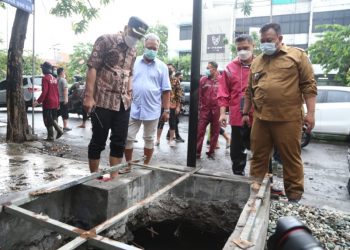 Menggunakan sandal jepit dan kemeja batik, Wali Kota Surabaya Eri Cahyadi melakukan pengecekan genangan air yang di kawasan Jalan Ngagel.