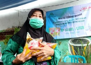 Salah satu warga setelah membeli minyak goreng dalam operasi pasar yang dilaksanakan Pemkot Surabaya.