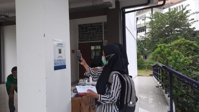 Mahasiswi Departemen Teknik Geofisika ITS saat melakukan scan PeduliLindungi sebelum masuk kelas PTM.