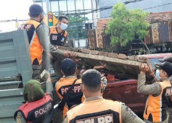 Personel Satpol PP melakukan penertiban PKL di kawasan Gembong dengan mengangkuti lapak yang digunakan para pedagang ke truk.
