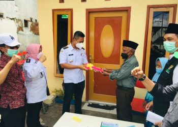 Proses penyerahan kunci rumah kepada kakek Kusno setelah rumahnya selesai diperbaiki.