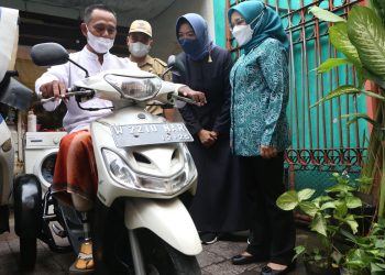 Penyandang disabilitas, Nur Nasihin mencoba menaiki motor modifikasi yang diserahkan Ketua Tim Penggerak (TP) PKK Kota Surabaya Rini Indriyani.