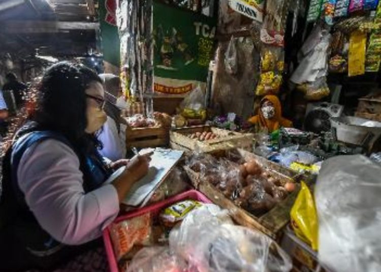 Salah satu petugas melakukan pengawasan ketersediaan bahan pangan, harga pangan dan keamanan pangan segar di pasar tradisional di Surabaya.