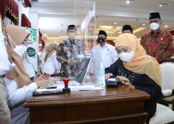 Gubernur Jatim Khofifah Indar Parawansa menyerahkan zakat melalui Baznas. Pembayaran zakat ini selain bisa dilakukan secara tunai, juga bisa dilakukan melalui pembayaran non tunai atau QRIS.