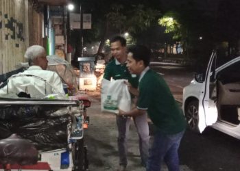 Tim dari MW Kahmi Jatim memberikan paket sembako kepada tukang becak di salah satu jalan protokol di Surabaya.
