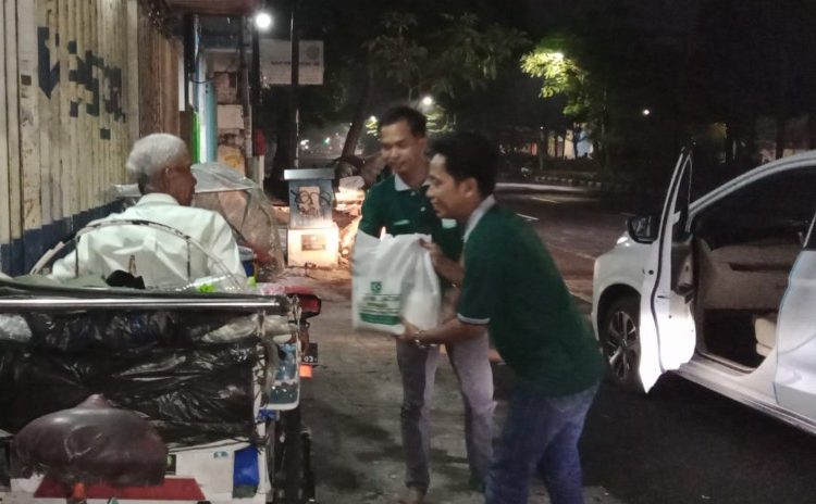 Tim dari MW Kahmi Jatim memberikan paket sembako kepada tukang becak di salah satu jalan protokol di Surabaya.