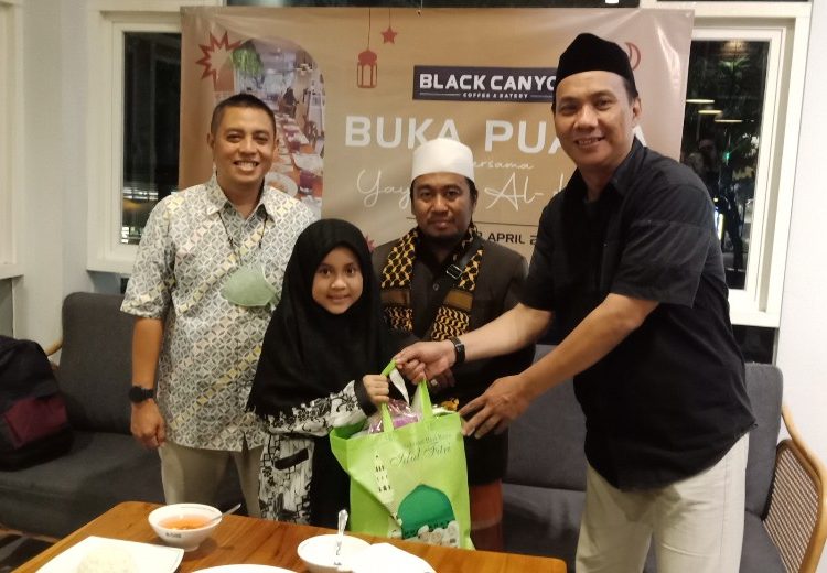 Perwakilan manajemen Black Canyon memberikan bingkisan kepada anak yatim piatu dari Yayasan Al-Kahfi.