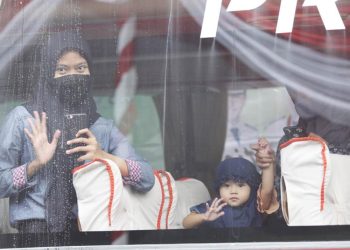 Seorang ibu dan anak yang mengikuti Mudik Bareng Gratis Tahun 2022 sebelum diberangkatkan dari Surabaya.