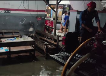 Petugas Dinas Pemadam Kebakaran (Damkar) Pemkab Bojonegoro bersama warga bahu membahu mengatasi genangan akibat hujan deras yang menggenangi pemukiman.