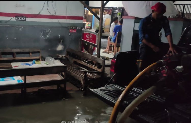 Petugas Dinas Pemadam Kebakaran (Damkar) Pemkab Bojonegoro bersama warga bahu membahu mengatasi genangan akibat hujan deras yang menggenangi pemukiman.