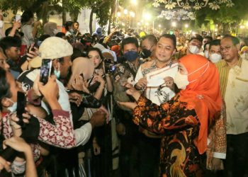 Gubernur Jawa Timur Khofifah Indar Parawansa bersama Wali Kota Surabaya Eri Cahyadi menyapa masyarakat yang menyaksikan parade bunga dan parade budaya dalam 'Surabata Vaganza' di Jalan Tunjungan, Surabaya.