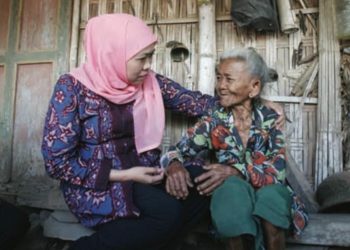 Gubernur Jatim Khofifah Indar Parawansa dalam salah satu kegiatannya bersama seorang lansia.