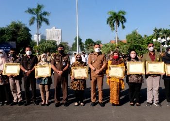 Wali Kota Surabaya Eri Cahyadi bersama perwakilan koperasi yang menerima piagam penghargaan di halaman Balai Kota Surabaya.