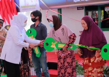 Gubernur Jawa Timur Khofifah Indar Parawansa secara simbolis menyerahkan kunci rumah kepada warga yang rumahnya direnovasi dalam program rutilahu.