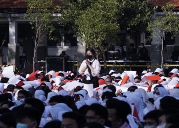 Hasna Nur Shadrina (berdiri) ketika disebutkan sebagai mahasiswa termuda 2022 dalam kegiatan pengukuhan mahasiswa baru di Lapangan Gedung Perpustakaan ITS.