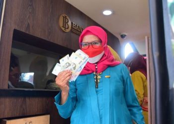 Salah satu guru yang mendapatkan Tanda Kehormatan Satyalancana Karya Satya di Gedung Negara Grahadi menerima uang kertas baru.