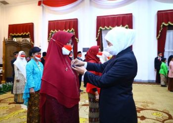 Gubernur Jawa Timur Khofifah Indar Parawansa menyematkan Tanda Kehormatan Satyalancana Karya Satya kepada guru SMA/SMK di Jatim.