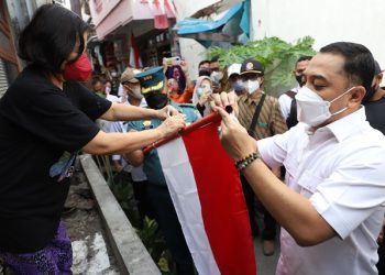 Wali Kota Surabaya Eri Cahyadi memasangkan bendera merah putih ke salah satu rumah warga di kawasan Tambaksari, Surabaya.