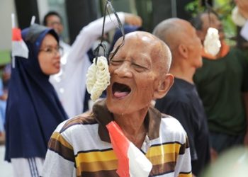 Para lansia mengikuti lomba makan kerupuk dalam peringatan HUT Kemerdekaan RI ke-77 di UPTD Griya Wreda Jambangan.
