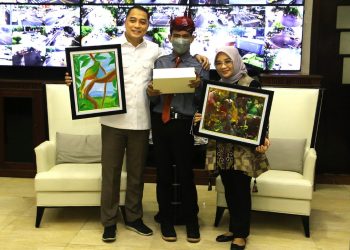 Wali Kota Surabaya Eri Cahyadi bersama Ketua Tim Penggerak (TP) PKK Kota Surabaya Rini Indriyani menunjukkan lukisan karya dari penyandang disabilitas Rizky Gusti Priambodo.