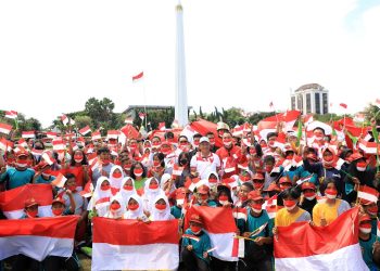 Mendagri Tito Karnavian, Gubernur Jatim Khofifah Indar Parawansa dan Wali Kota Surabaya Eri Cahyadi dalam pembagian bendera merah putih di Tugu Pahlawan.