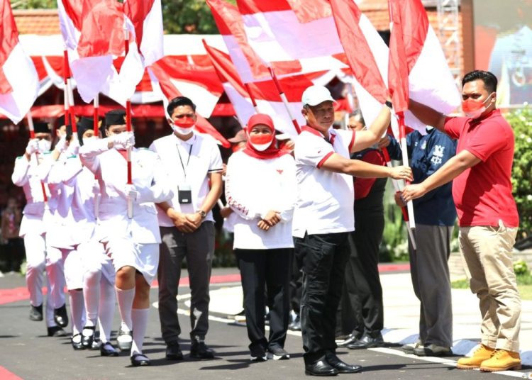 Menteri Dalam Negeri Tito Karnavian didampingi Gubernur Jawa Timur Khofifah Indar Parawansa memberikan bendera dalam Gerakan Berbagi 10 Juta Bendera Merah Putih.
