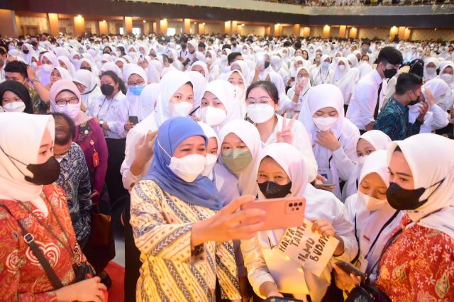 Gubernur Jawa Timur Khofifah Indar Parawansa melayani swafoto dengan mahasiswa baru Unair, di Airlangga Convention Center Unair.