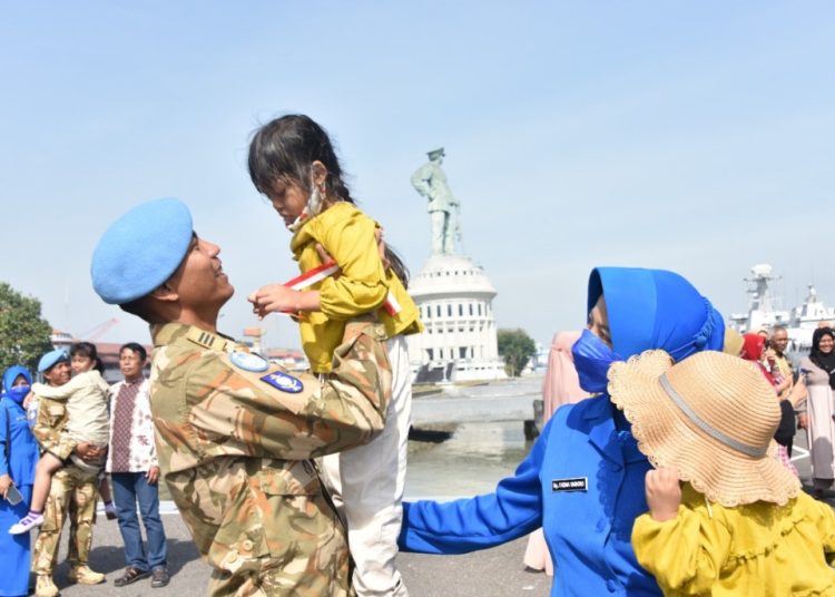 Personel KRI Sultan Iskandar Muda (SIM) - 367 menggendong anaknya setelah tiba di Dermaga Madura Tengah, Koarmada II, Ujung Surabaya.