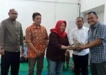 Ketua Badan Pengawas PD Pasar Surya Novy Ispinari memberikan potongan tumpeng ke Direktur Utama PD Pasar Surya Agus Priyo disaksikan direksi dan anggota Badan Pengawas yang lain.