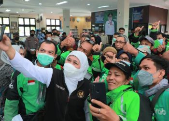 Gubernur Jawa Timur Khofifah Indar Parawansa berswafoto dengan drivel ojol di sela kembali menyalurkan program perlindungan sosial dampak inflasi dan kenaikan BBMdi Sidoarjo.