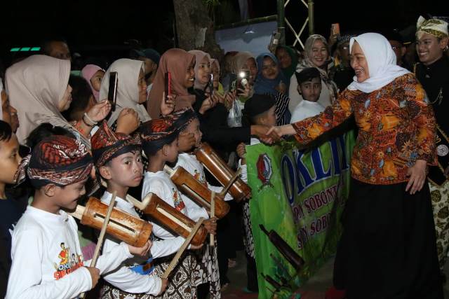 Bupati Bojonegoro Anna Mu’awanah menyapa anak-anak yang memainkan kesenian dalam acara lunching HKI Oklik Bojonegoro di lapangan Desa Sobontoro, Kecamatan Balen.