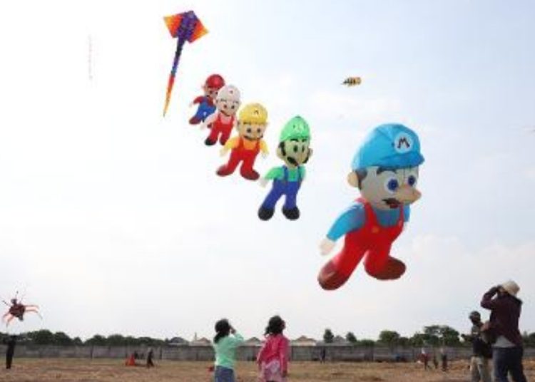 Salah satu peserta menerbangkan layang-layang dalam Surabaya Kite Festival 2022 di Long Beach Area Selatan, Pakuwon City, Surabaya.