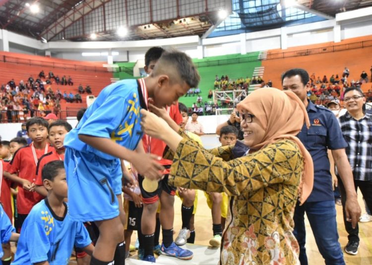 Kepala Dinas Kebudayaan, Kepemudaan dan Olahraga serta Pariwisata Kota Surabaya Wiwiek Widayati mengalungkan medali kepada juara dalam penutupan Pormaskot di GOR Indoor GBT.
