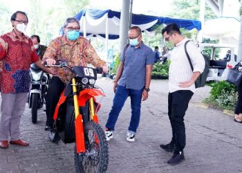Vice President Director PT Toyota Motor Manufacturing Indonesia Nandi Julyanto mencoba mengendarai sepeda motor listrik E-Trail karya ITS yang juga dipamerkan.