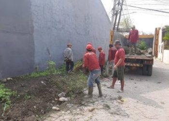 Personel Dinas Lingkungan Hidup Surahaya mengangkut sampah hasil kerja bakti “Surabaya Bergerak”