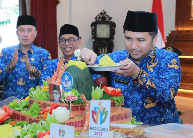 Wakil Gubernur Jatim Emil Elestianto Dardak memotong tumpeng tasyakuran peringatan Hari Guru 2022 dan HUT PGRI ke - 77 tahun yang diselenggarakan di Gedung Negara Grahadi Surabaya.