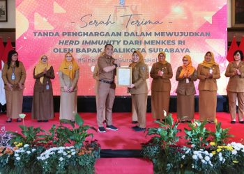 Wali Kota Surabaya Eri Cahyadi menyerahkan penghargaan Kemenkes RI kepada Kepala Dinas Kesehatan (Dinkes) Surabaya Nanik Sukristina atas tercapainya herd immunity di Kota Surabaya.